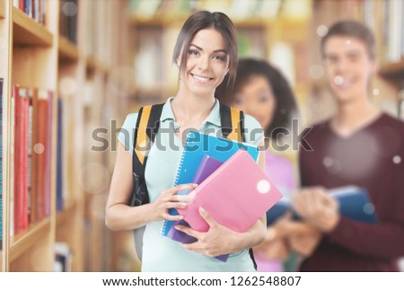 Portrait of a cute young student girl holding colorful notebook