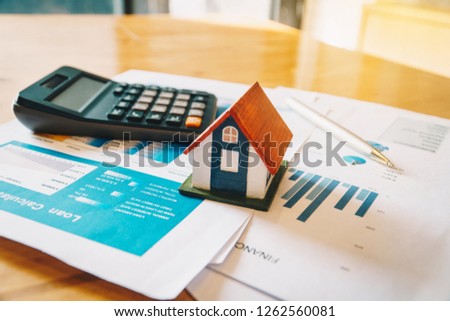 House model,Calculator and financial chart  on wooden table. Investment to buying property concept. Royalty-Free Stock Photo #1262560081