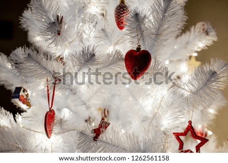 white christmas tree with red toys background close up warm led