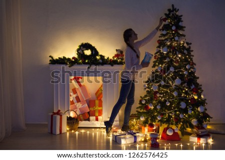 woman decorates a Christmas tree new year gifts Garland lights