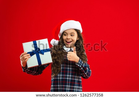 New year party. Santa claus kid. Christmas shopping. Present for Xmas. Childhood. Little girl child in santa red hat. Happy winter holidays. Small girl. presenting product.