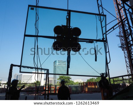 construction glass installtion construction workers installing glass wall of large building  Royalty-Free Stock Photo #1262613469