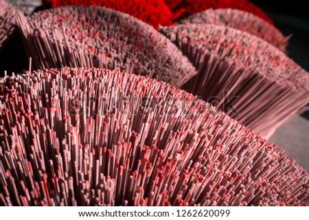 Many red incense sticks. It is such an beautiful abstract background.