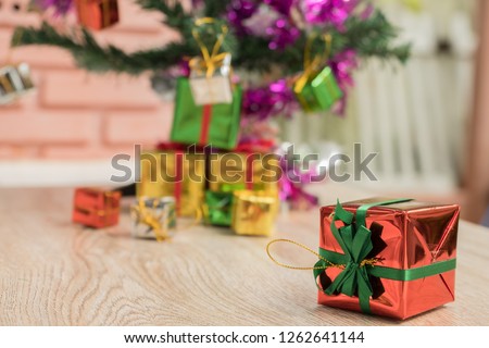 Green gift box in red, gold, silver on wooden floor on Christmas Eve and New Year's Day.