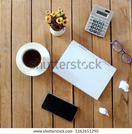   top view and flat lay Black  coffee cup  ,paper white  , smartphone  , glasses  on wooden desk office 