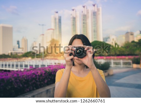 Asian woman photographer is taking a photo. 