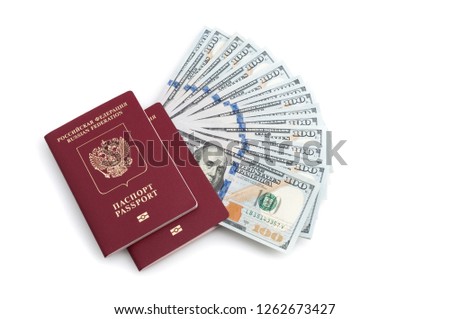 Two red passports and a hundred dollar bills on a white background.