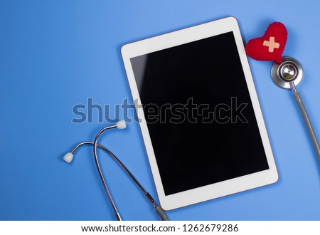 Medical application in tablet with health monitoring. Stethoscope with tablet on blue background. 
