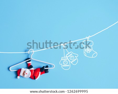 Lovely Santa Claus on hanger over blue background.