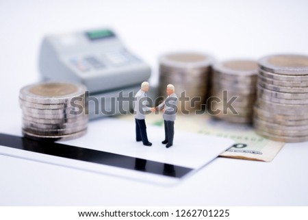Miniature people : Business group standing on credit card with cashier machine and coins. picture use for background shopping business concept.