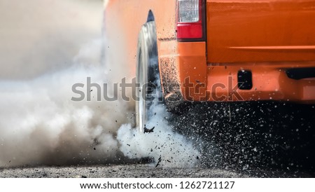 Drag racing car burns rubber off its tires in preparation for the race Royalty-Free Stock Photo #1262721127