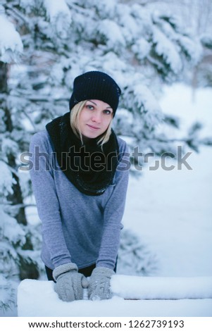 happy young woman in winter park for a walk in nature