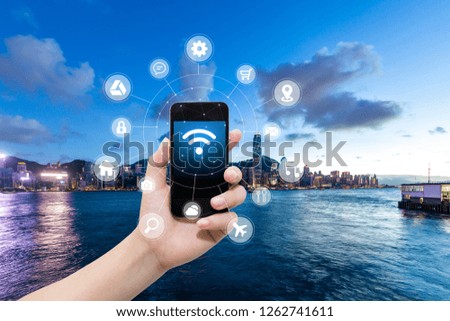 smart phone in hand and using internet wifi network connection communication technology concept on blurred city background