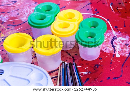 Paints, brushes, water. Everything that is necessary for the  artist. 
Also the palette is a lot of different brushes. Objects for drawing.
Concept art creativity. Jars with different paints.