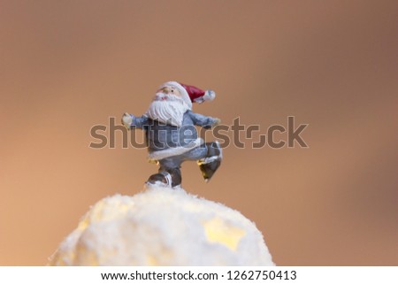 Ice skating Santa on top of a snowy christmas tree ball