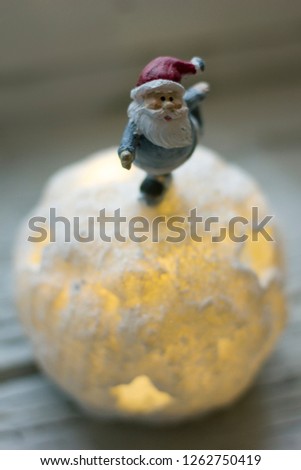 Ice skating Santa on top of a snowy christmas tree ball