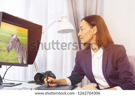 Female photographer retouching photos in office