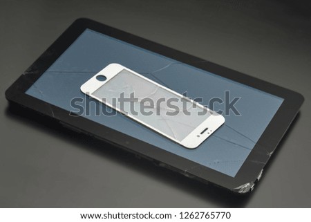 Broken tablet and broken protective glass from a smartphone, close-up