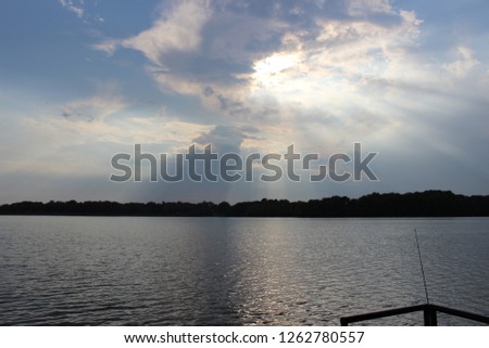 Sun Rays Poking Through the Clouds over the Silver Lake, Illinois during Fishing