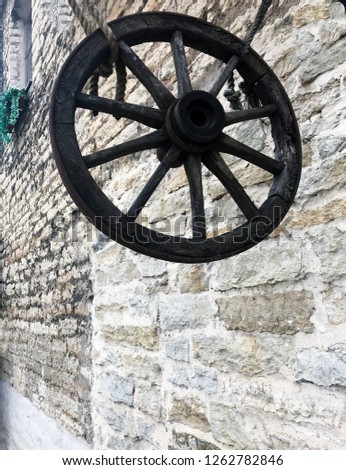 
The huge old wheel from the wagon, suspended by rope ropes against the background of an old brick wall - an excellent decor that creates the atmosphere.