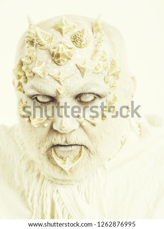 Reptilian man with blind eyes and grey beard on thorny skin face on white background. Mystery and fantasy concept.