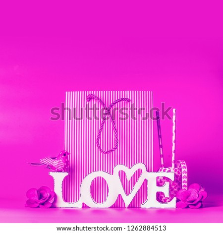 Creative love background concept in neon color. Word Love sign at shopping bag and decorations . Valentines day greeting and shopping sale, abstract love symbol template or layout