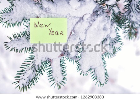 winter tree under the snow with a sticker and inscription new year