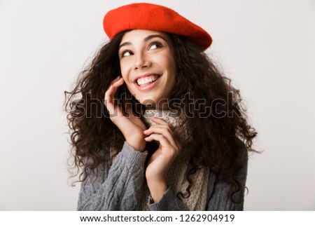 Excited young woman wearing autumn clothes standing isolated over white background, looking away