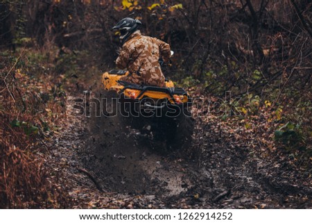 Man riding fix quad on a muddy path