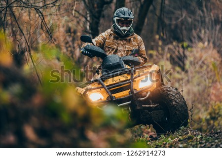 Male driving fix quad through the forest Royalty-Free Stock Photo #1262914273