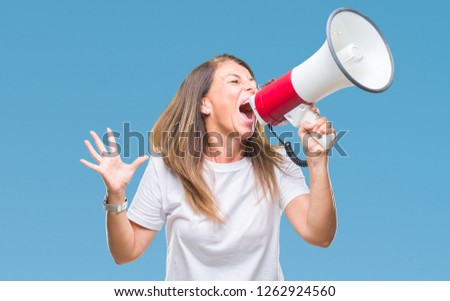 Middle age hispanic woman yelling through megaphone over isolated background annoyed and frustrated shouting with anger, crazy and yelling with raised hand, anger concept