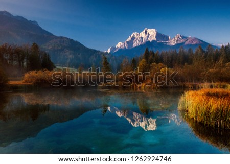 Picture of a small lake reflecting the triglav mountains on the surface. Location Reservat Zelenci, Slovenia.