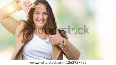 Beautiful plus size young woman wearing winter coat over isolated background smiling making frame with hands and fingers with happy face. Creativity and photography concept.
