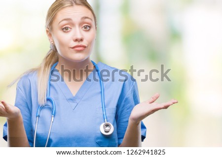 Young blonde surgeon doctor woman over isolated background clueless and confused expression with arms and hands raised. Doubt concept.