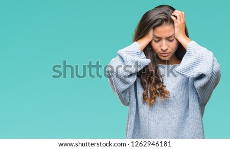 Young beautiful arab woman wearing winter sweater over isolated background suffering from headache desperate and stressed because pain and migraine. Hands on head. Royalty-Free Stock Photo #1262946181
