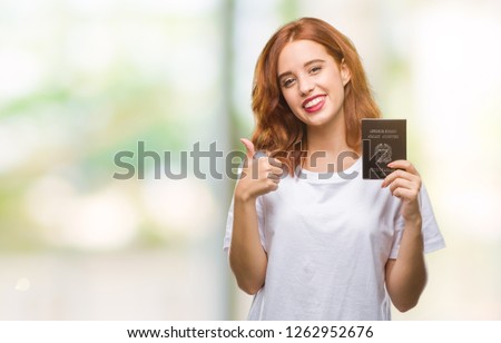 Young beautiful woman holding passport of italy over isolated background happy with big smile doing ok sign, thumb up with fingers, excellent sign