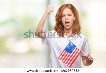 Young beautiful woman holding flag of america over isolated background annoyed and frustrated shouting with anger, crazy and yelling with raised hand, anger concept