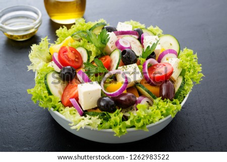 Greek salad with feta cheese, organic black olives, juicy tomatoes, red pepper, red onion, cucumber and lettuce. Royalty-Free Stock Photo #1262983522
