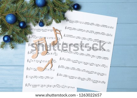 Composition with wooden music notes and Christmas balls on table, top view