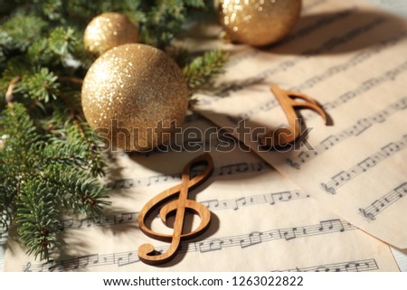 Composition with Christmas balls and wooden music notes on table