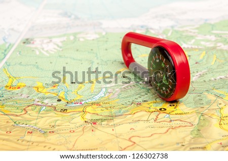 An image of red pocket compass and road map