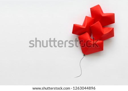 Valentines day card. Red paper heart shape balloons on thread. Origami and minimalist concept