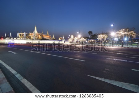 Light trail of Bangkok Tuk Tuk on the Ratchadamnern road with Grand Palace Bangkok, shooting with long exposure then blurring all movements on a night moment.