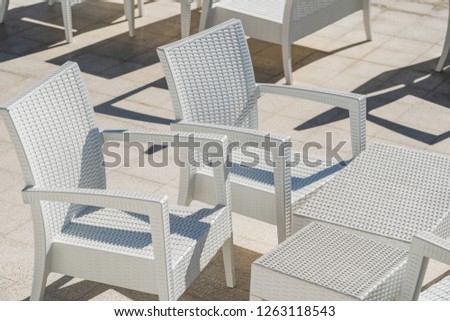 White tables and chairs at street cafe. Horizontal color photography.