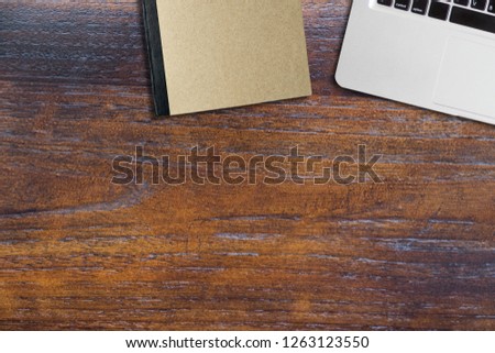 Computer note book and book on wooden table, copy space