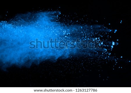 Abstract blue powder splatted background. Colorful powder explosion on black background. Colored cloud. Colorful dust explode. Paint Holi.