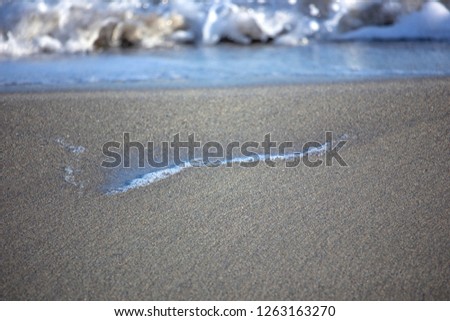 Sea surf paints pictures in the sand.