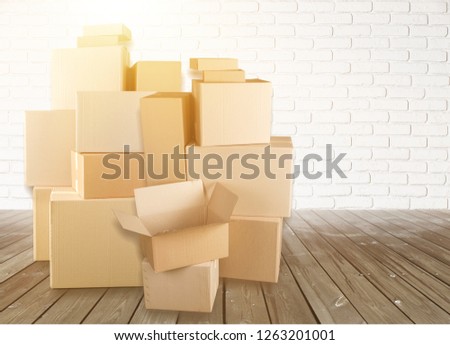 Different cardboard boxes in room on wooden floor