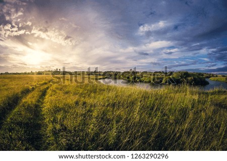 landscape of the riverbank at sunset with the sun above the horizon