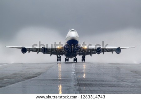 Passenger wide body airliner takes off from wet runway. Royalty-Free Stock Photo #1263314743